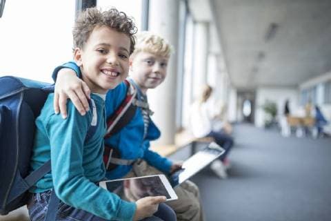 IMAGO Creative: Gesellschaft, Integration Portrait of two smiling schoolgboys with tablet embracing model released Symbolfoto property released  WESTF24179