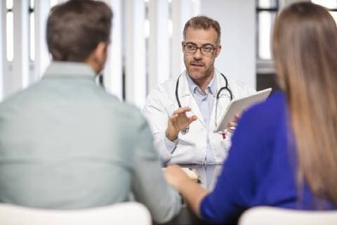 Doctor talking to couple in medical practice model released Symbolfoto property released  ZEF15519
