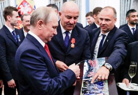 MOSCOW, RUSSIA - JULY 28, 2018: The President of Russia Vladimir Putin (front) and the head coach of Russian s national team Stanislav Cherchesov (C) look at photographs after a ceremony to present government awards to Russia s national men s football team and coaches at the Kremlin; the Russian national team reached the quarterfinals at the 2018 FIFA World Cup. Mikhail Metzel TASS  TS08B0B1