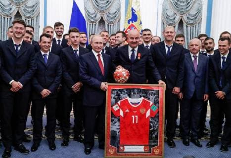 MOSCOW, RUSSIA - JULY 28, 2018: Football player Anton Miranchuk, coach of Russia s national men s football team Pulino Granero, football player Alexander Golovin, the President of Russia Vladimir Putin, the head coach of Russia s national team Stanislav Cherchesov, and coach of Russian s national football team Miroslav Romashchenko (from L front), and Russian football players and sports officials pose with a Number 11 football jersey for a photographafter a ceremony to present government awards to Russia s national men s football team and coaches at the Kremlin; the Russian national team reached the quarterfinals at the 2018 FIFA World Cup. Mikhail Metzel TASS  TS08B0AE