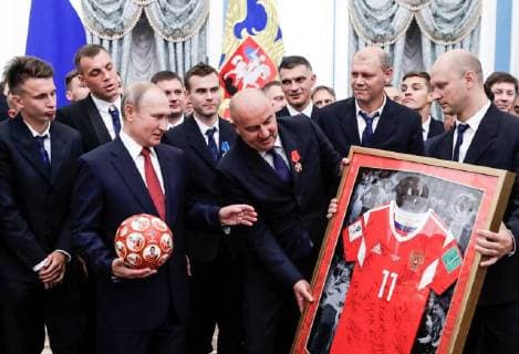 MOSCOW, RUSSIA - JULY 28, 2018: The President of Russia Vladimir Putin (2nd L front) receives a ball and a Number 11 football jersey from the head coach of Russian s national team Stanislav Cherchesov (C) and Russian football players after a ceremony to award national decorations to Russia s national men s football team and coaches at the Kremlin; the Russian national team reached the quarterfinals at the 2018 FIFA World Cup. Mikhail Metzel TASS  TS08B0C4