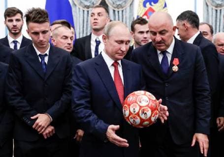 MOSCOW, RUSSIA - JULY 28, 2018: The President of Russia Vladimir Putin (C) receives a ball from the head coach of Russian s national team Stanislav Cherchesov (R) and Russian football players after a ceremony to award national decorations to Russia s national men s football team and coaches at the Kremlin; the Russian national team reached the quarterfinals at the 2018 FIFA World Cup; left front: football player Alexander Golovin. Mikhail Metzel TASS  TS08B0C0
