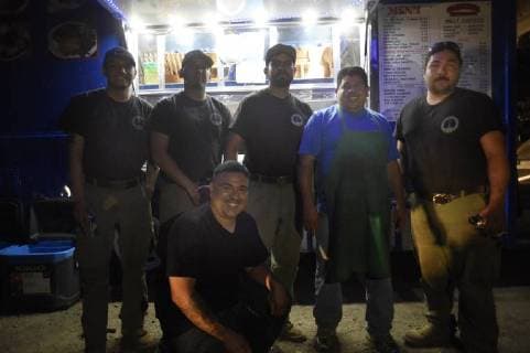 August 6, 2018 - Ukiah, California, USA - Ukiah, California, U.S. - ROBERTO MORENO, second from right, and his nephew TONY, kneeling, served tacos to firefighters from the family s taco truck. They are seen here with members of the Prescott Arizona Fire District crew that are part of the multi-state mutual aid team of fire personnel called in to assist CAL Fire with the Mendocino Complex. The fires in California and Oregon have grown so large that the National Interagency Fire Center has also coordinated with Australia and New Zealand to send fire fighters to the US. Ukiah USA - ZUMAw332 20180806_zap_w332_013 Copyright: xNealxWatersx