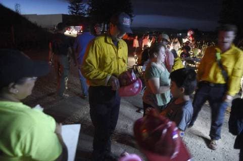 August 6, 2018 - Ukiah, California, USA - Ukiah, California, U.S. - A fire fighter from the Culver City Fire Department hands out toy fire helmets to kids outside the Incident Command Post. The children were there with their parents to greet the fire fighters and offer them a meal of tacos. Ukiah USA - ZUMAw332 20180806_zap_w332_014 Copyright: xNealxWatersx