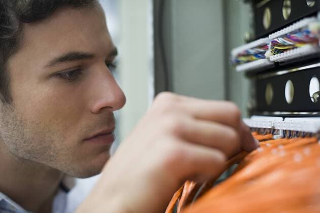 Computer technician performing maintenance work on networking equipment  Copyright: FrédéricxCirou B87168527