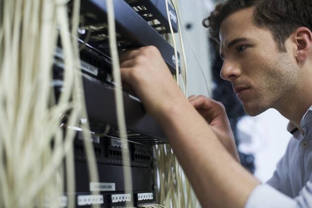 Computer technician performing maintenance on computer networking equipment  Copyright: FrédéricxCirou B94461227