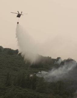 A helicopter dumps water along a ridge in Colusa County, California on August 7, 2018. The Mendocino Complex fire has become the largest in the state s history.  SXP2018080721 TERRYxSCHMITT