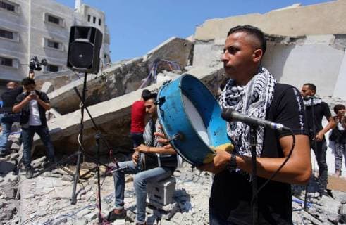 August 10, 2018 - Gaza City, Gaza Strip, Palestinian Territory - Members of a Palestinian musical band perform on the rubble of Said al-Mishal Cultural Center following an Israeli air strike destroyed it on the previous day, in Gaza city on Aug. 10, 2018 Gaza City Palestinian Territory - ZUMAap3_ 20180810_zaf_ap3_011 Copyright: xMahmoudxAjourx