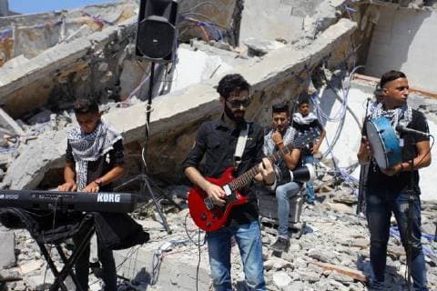 August 10, 2018 - Gaza City, Gaza Strip, Palestinian Territory - Members of a Palestinian musical band perform on the rubble of Said al-Mishal Cultural Center following an Israeli air strike destroyed it on the previous day, in Gaza city on Aug. 10, 2018 Gaza City Palestinian Territory - ZUMAap3_ 20180810_zaf_ap3_010 Copyright: xMahmoudxAjourx