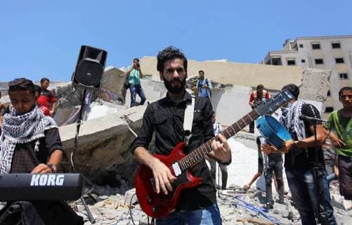 August 10, 2018 - Gaza City, Gaza Strip, Palestinian Territory - Members of a Palestinian musical band perform on the rubble of Said al-Mishal Cultural Center following an Israeli air strike destroyed it on the previous day, in Gaza city on Aug. 10, 2018 Gaza City Palestinian Territory - ZUMAap3_ 20180810_zaf_ap3_002 Copyright: xMahmoudxAjourx
