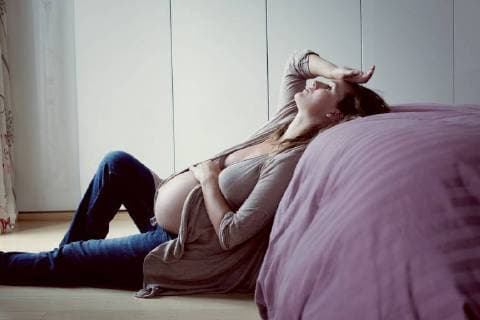 Pregnant woman leaning against bed relaxing  Copyright: Anne-SophiexBost B04313429