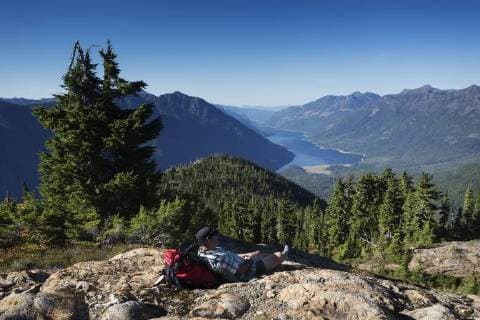 A lone hiker takes a break on the Flower Ridge trail overlooking Buttle Lake in Strathcona Park, Strathcona Park, Central Vancouver Island, British Columbia, Canada model released Symbolfoto  acp108170 BoomerxJerritt