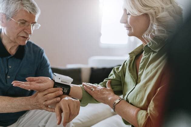 Senior couple taking blood pressure at home model released Symbolfoto property released  ZEDF00796