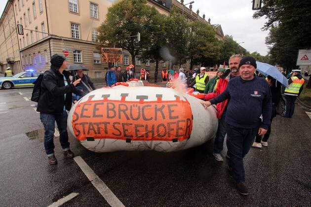 Demonstration pier Bridges instead of walls against the policy of foreclosure of the EU European Union through the harassment of aid vessels and organizations of refugee aid and the resulting mass extinction of refugees on the Mediterranean in Munich Bavaria Germany lifeboat with inscription pier instead Se