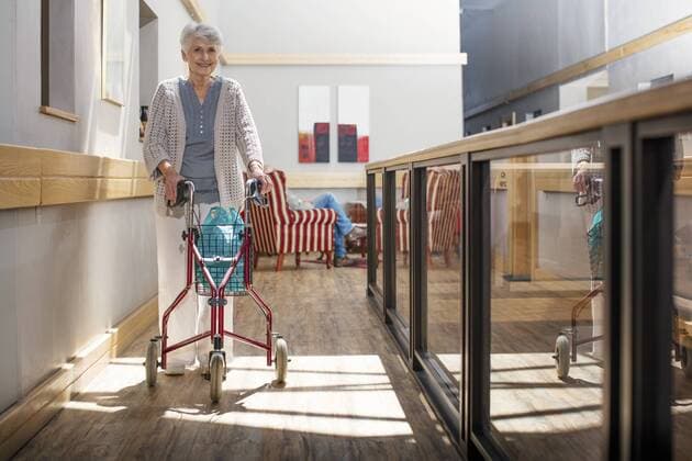 Senior woman in retirement home pushing wheeled walker model released Symbolfoto property released  ZEF14225