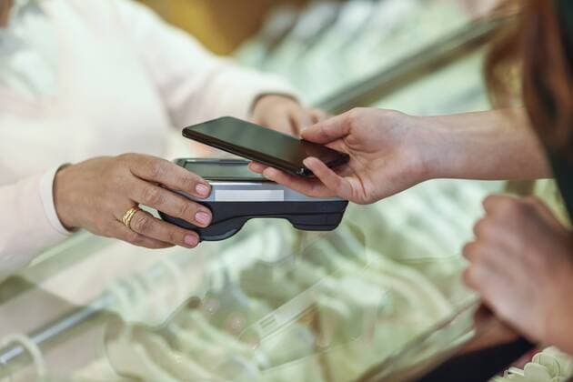 Close-up of woman paying with smartphone in a store model released Symbolfoto property released  JSMF00335