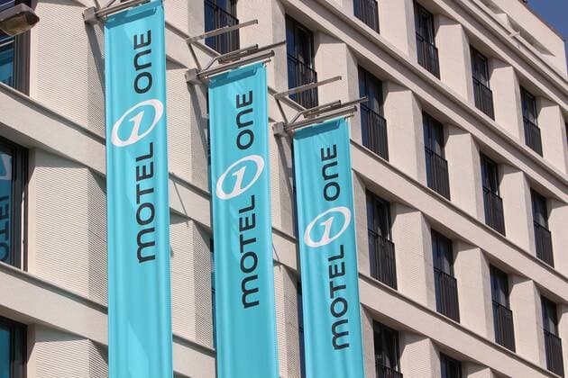 Flags with company logo Motel One on the facade of a new building in downtown Frankfurt Hesse Germany