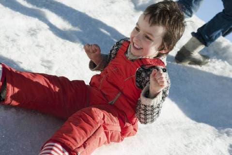 IMAGO Creative: Wintersport, Mode Boy sitting in snow, smiling  Copyright: JérômexGorin B24524413