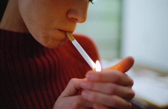 Young woman lighting cigarette  Copyright: PatrickxMacxSean B83023601