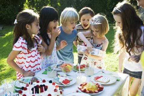 Geburtstag - Symbolbilder Girl opening gift at birthday party as friends watch  Copyright: SigridxOlsson B51499706