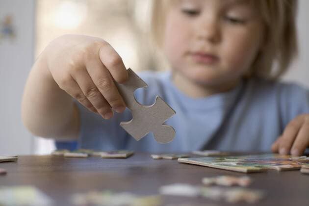 A young boy holding a puzzle piece  Copyright: VladimirxGodnik fStopImages1046027