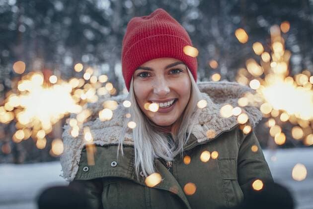 Portrait of smiling woman holding sparklers during winter  Copyright: VasilyxPindyurin fStopImages1486057