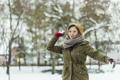 Portrait of woman throwing snowball model released Symbolfoto  ZEDF00803