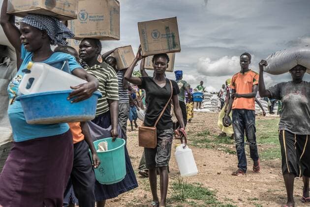 May 7, 2018 - Uganda - South Sudanese female refugees seen carrying palm oil on top of their heads as they were given these food supply by the world food program. The Bidi Bidi refugee settlement in northern Uganda near the South Sudanese border is currently the largest refugee camp in the world, hosting over 250,000 South Sudanese refugees fleeing the conflict. The world food program is providing monthly basic food supply for the refugees in the settlement. Uganda - ZUMAs197 20180507_zab_s197_015 Copyright: xAldaxTsangx