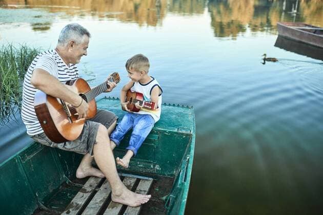 Grandfather teaching grandson playing guitar model released Symbolfoto  ZEDF01499