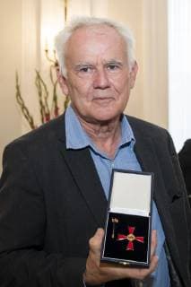 Jim Rakete poses for a picture with the Cross of Merit of the Order of Merit of the Federal Republic of Germany at Schloss Bellevue in Berlin on October 2, 2018 Award of Merit in Berlin