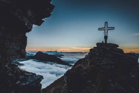 THEME IMAGE Hikers with the summit cross of the Tristkogel during the sunrise over the clouds taken on 16 September 2018 in Saalbach Hinterglemm Austria Hiker with the summit of the Tristkogel during the sunrise over the clouds Saalbach Hinterglemm Austria on 2018 09 16  EX_OBH