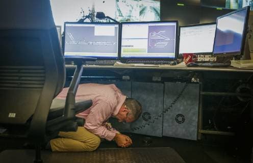(181019) -- VANCOUVER, Oct. 19, 2018 (Xinhua) -- A staff member takes cover under the table inside the Canada Line s control room during the Great Shakeout earthquake exercise in Vancouver, Canada, on Oct. 18, 2018. About 910,000 people participated in the annual Great Shakeout earthquake exercise in British Columbia of Canada. A simulated exercise conducted by Canada Line - Vancouver s driverless, computer-controlled train system, to practice how the transit operators and residents react after the earthquake early warning system issue alert. (Xinhua Liang Sen) (qxy) CANADA-VANCOUVER-EARTHQUAKE-DRILL 