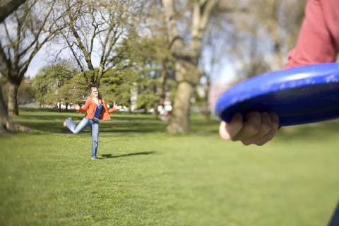 SEATTLE, WASHINGTON. A man throws a frisbee to Kire Dassel in Greenlake Park. The sunny days draw crowds to the many parks in Seattle, Washington., Seattle Washington United States model released Symbolfoto Copyright: MichaelxHanson 9627400016