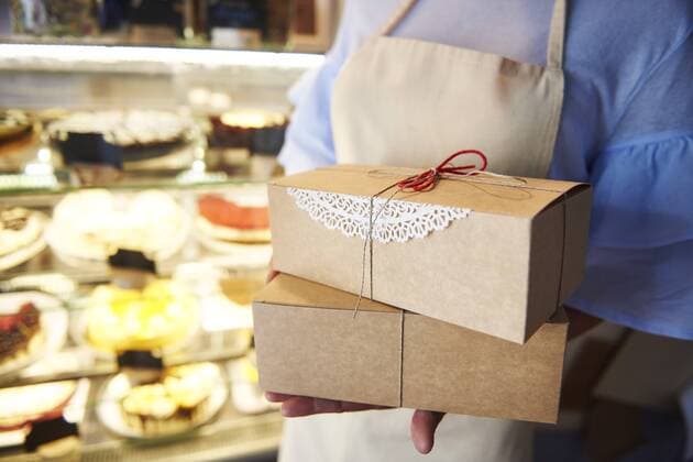 Close-up of woman holding cake boxes in a confectionery shop model released Symbolfoto property released  ABIF00837