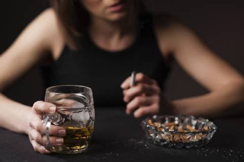 Portraet einer deprimierten und alkoholisierten Frau mit Bierglass und Zigarette in der Hand Portrait of a depressed and alcoholised woman with a glass of beer and a cigarette in her hands BLWS502151 Copyright: xblickwinkel McPHOTO M.xBegsteigerx