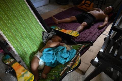 October 26, 2018 - Mapastepec, Chiapas, Mexico - As a caravan of thousands of Honduran migrants presses north, reaching the town of Arriaga on Friday, President Trump began considering ways to stop them, including suspending the right to claim asylum in the US, wich has became the main way of gaining entry to the country. A baby and her uncle rest on a good samaritan house. Mapastepec Mexico - ZUMAl113 20181026_zap_l113_014 Copyright: xMiguelxJuarezxLugox