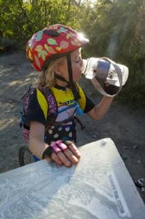 A Girl Drinking Water From A Bottle Next To A Trail Sign While Mountain Biking On The Horse Gulch Trail System, Durango Colorado usa model released Symbolfoto Copyright: KennanxHarvey HAKE000855