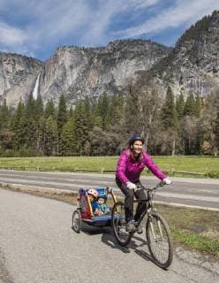 Woman bike riding with kids, Yosemite in backgound, Yosemite National Park California USA model released Symbolfoto Copyright: JoshxMillerxPhotography MIOS001243