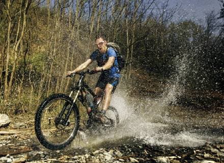 Guy rides his mountain bike over mountain stream. Image captured at the moment of a biggest splash. Taken on Gledic mountains near Kragujevac, Central Serbia at a sunny Spring day., Kragujevac Serbia Serbia model released Symbolfoto Copyright: MarkoxRadovanovic RAMA000696
