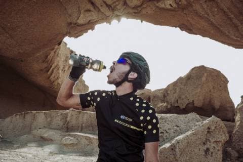 Mountain bike cyclist drinks water during ride in desert, Tenerife, Canary Islands, Spain, Tenerife Canary Islands Spain model released Symbolfoto Copyright: SergioxVillalba VISE003001
