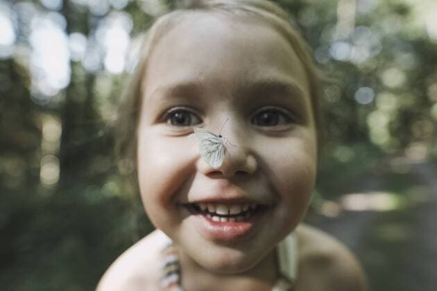 Portrait of smiling little girl with butterfly on her nose model released Symbolfoto  KMKF00465