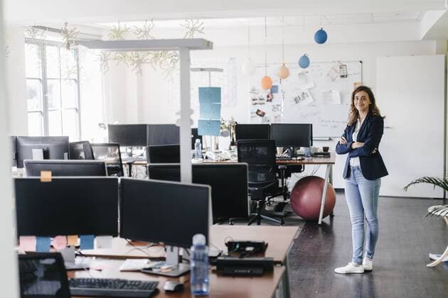 Confident businesswoman standing smiling in office model released Symbolfoto property released  KNSF02755
