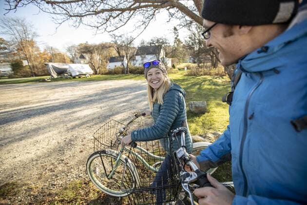 Young couple smiling while walking with bikes across village in fall, Portland, Maine, USA, portland ME USA BECR000741 model released Symbolfoto Copyright: ChrisxBennett BECR000741