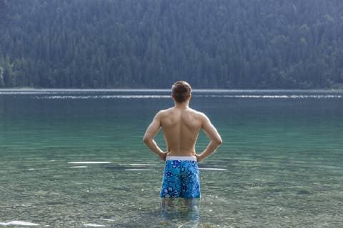 Germany, Bavaria, Eibsee, back view of young man standing in water model released Symbolfoto  TCF05446