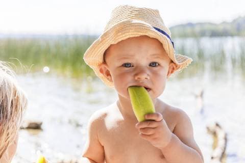 Baby boy eating melon at lake model released Symbolfoto  TCF05673