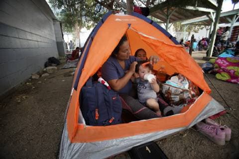 November 15, 2018 - San Diego, California, USA - Sitting her their tent Ana Marlene Bueso combs the hair of her son David Pineda with her daughter Angela in the background. The family set up for the night at the temporary shelter at the Unidad Deportiva Benito Juarez, a municipal gym in Tijuana. San Diego USA - ZUMAs44_ 20181115_zaf_s44_010 Copyright: xNelvinxC.xCepedax