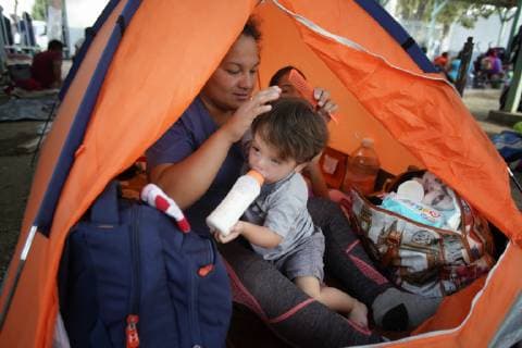 November 15, 2018 - San Diego, California, USA - Sitting in her tent Ana Marlene Bueso combs the hair of her son David Pineda with her daughter Angela in the background. The family set up for the night at the temporary shelter at the Unidad Deportiva Benito Juarez, a municipal gymnasium in Tijuana. San Diego USA - ZUMAs44_ 20181115_zaf_s44_009 Copyright: xNelvinxC.xCepedax