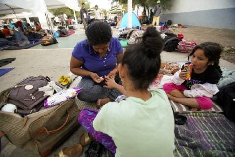 November 15, 2018 - San Diego, California, USA - At the temporary shelter set up at the Unidad Deportiva Benito Juarez, a mother from Hunduras who arrived with the first group with the central American migrant caravan uses a wet wipe to bathe her daughter on Wednesday. San Diego USA - ZUMAs44_ 20181115_zaf_s44_001 Copyright: xNelvinxC.xCepedax