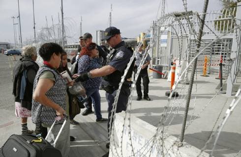 Migrant caravan Migrants from Central America have their backgrounds checked in Tijuana on the Mexican side of the border with the United States on Nov. 19, 2018. 