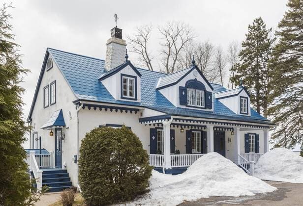 Old 20s white roughcast with blue house facade in country house style with blue steel tiled roof in spring Quebec Canada North America Copyright: imageBROKER/PerryxMastrovito ibxpmt04780010.jpg